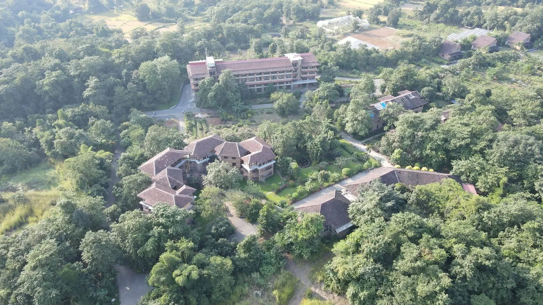 Aerial view of Govardhan Eco Village surrounded by fields and forest